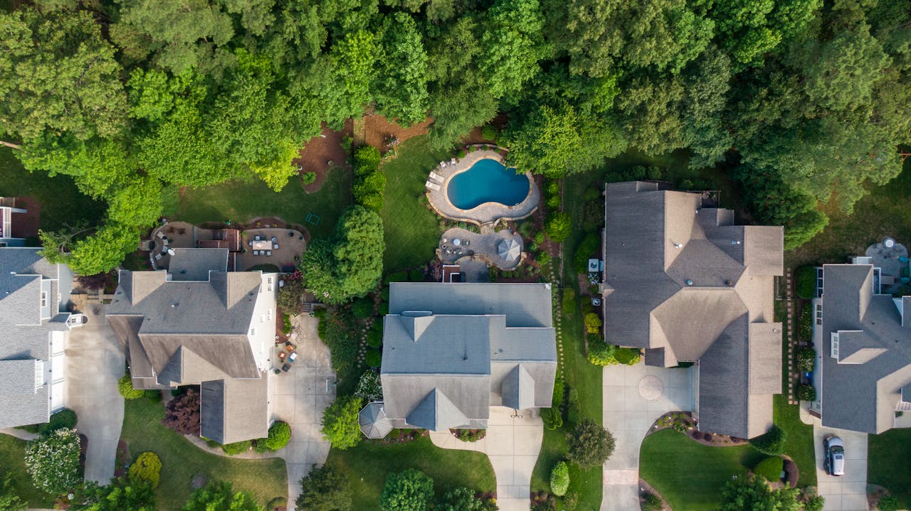 Vue aérienne de maisons avec piscines, illustration de la détection des bassins non déclarés par l'IA du fisc.
