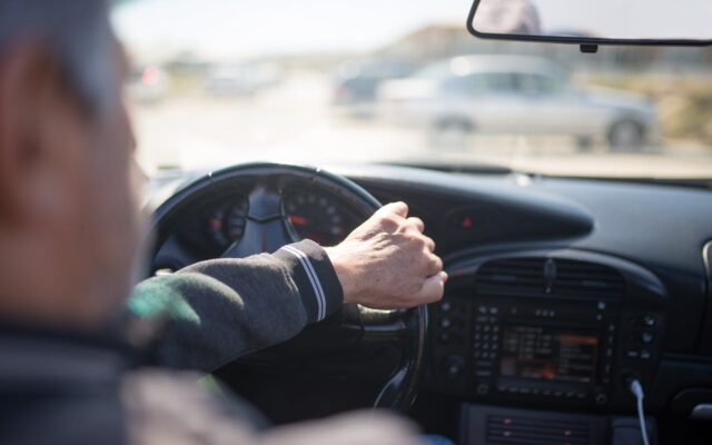 Mains d'un conducteur senior sur le volant, illustration du débat sur la fin du permis de conduire à vie en Europe.