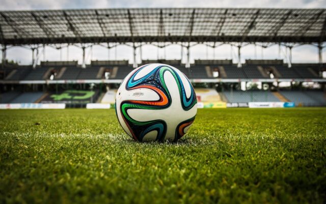 Ballon de football sur pelouse de stade illustrant la Coupe du Monde 2026