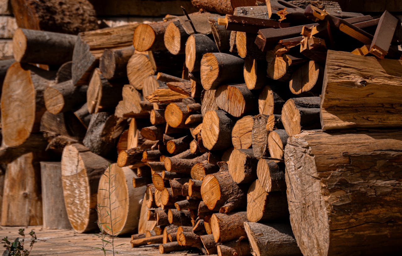 Bûches de bois empilées séchant au soleil, illustration de l'achat de bois de chauffage en été pour économiser.
