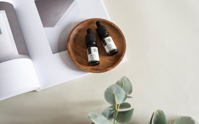 Feuilles de chanvre et flacon de CBD sur fond clair illustrant la nouvelle réglementation française
