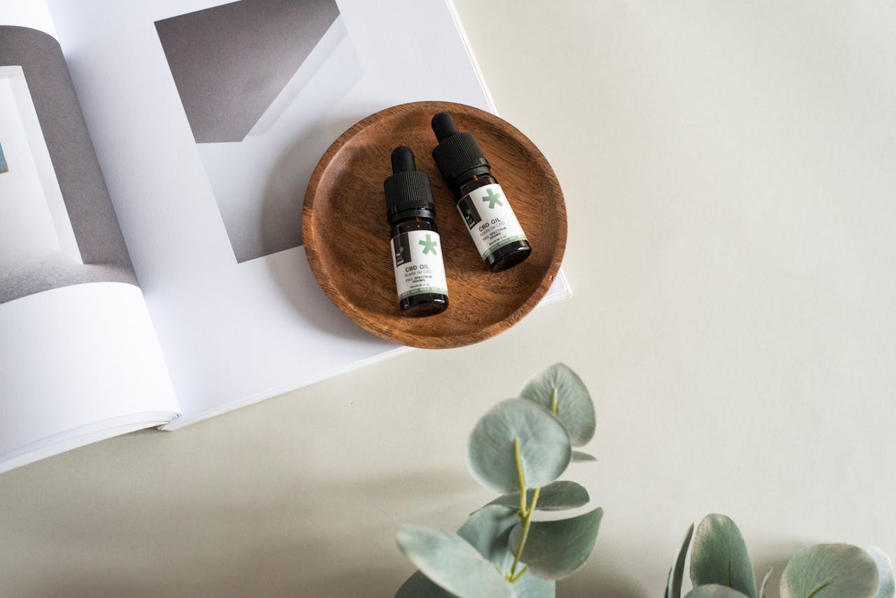Feuilles de chanvre et flacon de CBD sur fond clair illustrant la nouvelle réglementation française